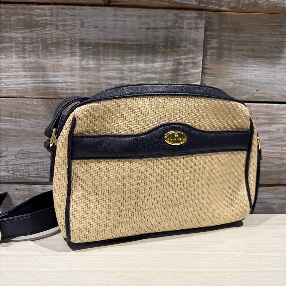 vintage Etienne Aigner straw crossbody bag with navy blue leather trim.